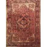 A North West Persian carpet with central red and ivory panel bordered by stylised geometric