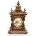 An early 20th Century oak eight day strike mantle clock Roman numerals to a white dial below a