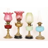 Two Victorian oil lamps each with cranberry shades,