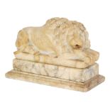A 19th Century carved alabaster recumbent lion with flowing mane, on separate stand and base,