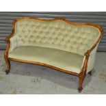 A Victorian carved walnut two seat settee with buttoned down pale green upholstery,
