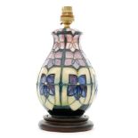 A Moorcroft Pottery table lamp decorated in the Violet pattern designed by Sally Tuffin,