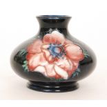 A small Moorcroft vase of compressed form decorated in the Anemone pattern against a blue wash