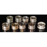 Two pairs of hallmarked silver circular napkin rings with five further silver examples,