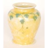 A Ruskin Pottery yellow lustre footed vase decorated with a garland of hand painted ivy to the