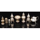 A parcel lot of hallmarked silver peppers with an open salt and a cauldron shaped covered mustard,