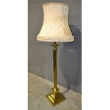 A 20th Century brass standard lamp with Corinthian column over a stepped base, complete with shade,