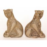 A pair of later 20th Century studio pottery models of seated leopards,