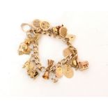 A 9ct hallmarked filed curb bracelet terminating in padlock fastener with various charms attached,