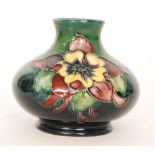 A small Moorcroft vase of compressed form decorated in the Columbine pattern against a green wash