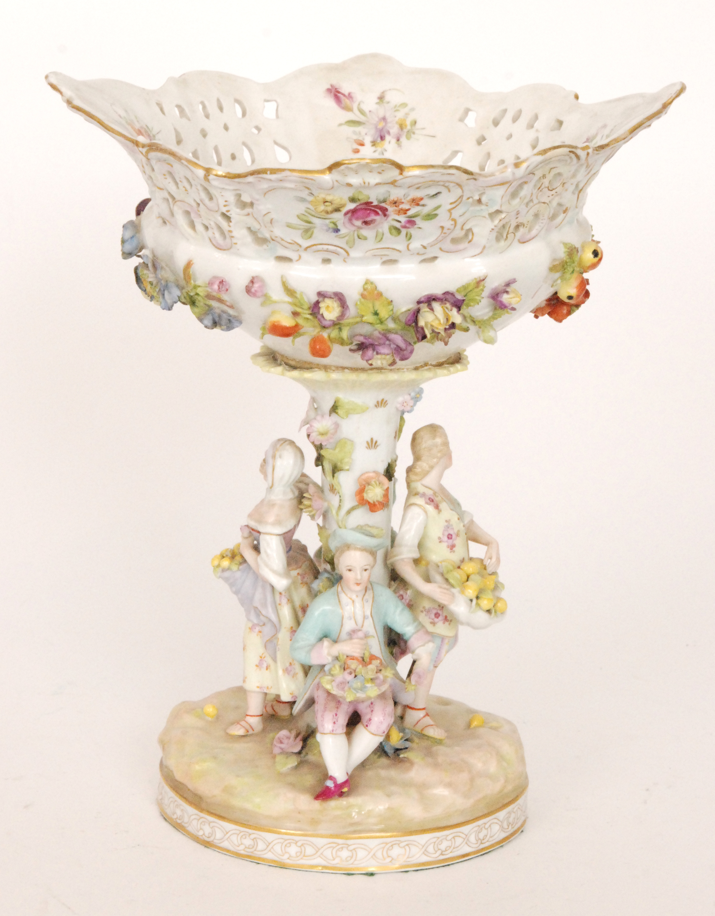 An early 20th Century floral encrusted pedestal fruit basket with figures stood around the central