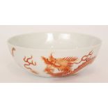 A Chinese shallow bowl decorated to the exterior with two burnt red hand painted dragons chasing