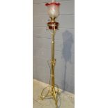 An Edwardian Art Nouveau style brass standard lamp on swept open work base and floral feet with