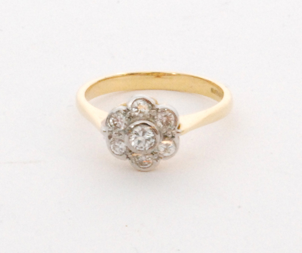 An 18ct diamond daisy cluster ring, collar set brilliant cut diamond within a six diamond surround,