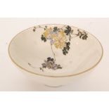 A Japanese Satsuma bowl with painted and enamelled trailing clematis decoration against a cream