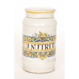 An early 20th Century tin glazed maiolica type drug jar decorated to the front with a rectangular