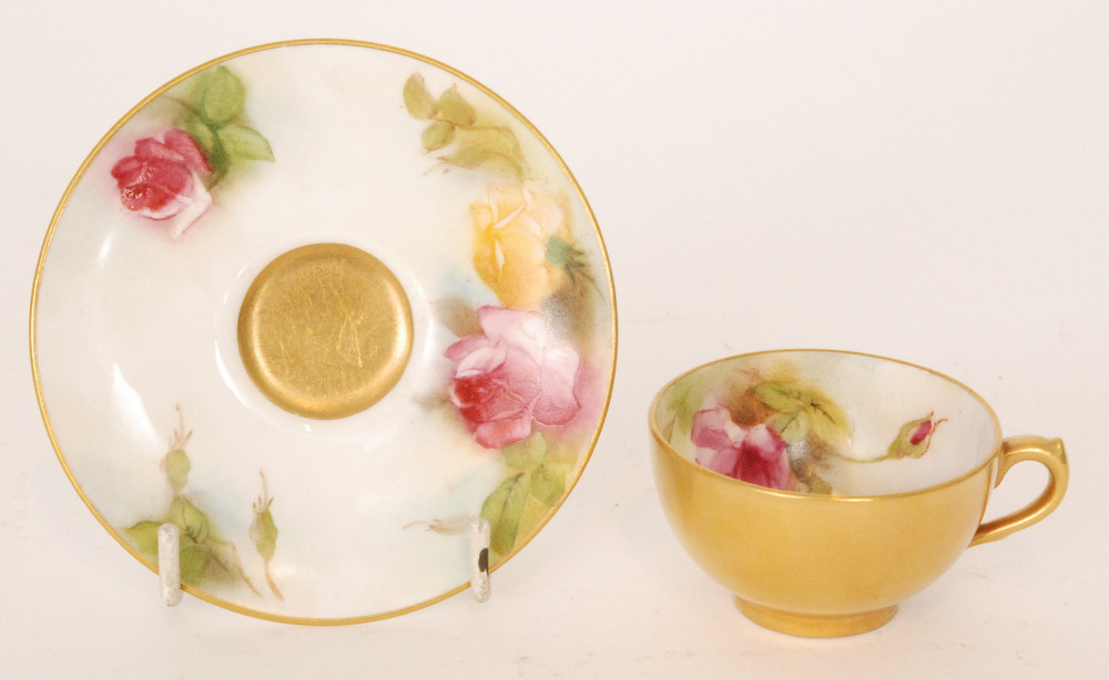 A Royal Worcester cabinet cup and saucer decorated with hand painted roses to the interior of the