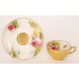 A Royal Worcester cabinet cup and saucer decorated with hand painted roses to the interior of the