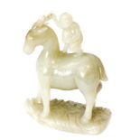 A Chinese celadon jade carving of a standing horse with a monkey standing on its back holding a