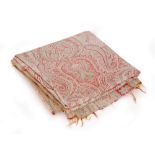 An early 20th Century Paisley shawl mainly in a pale red and green with repeat stylised patterns,