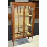 An Edwardian satinwood crossbanded and line inlaid display cabinet enclosed by a pair of bar glazed