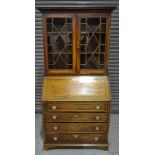 A Georgian mahogany bureau bookcase, with a dentil cornice above astragal glazed double doors,