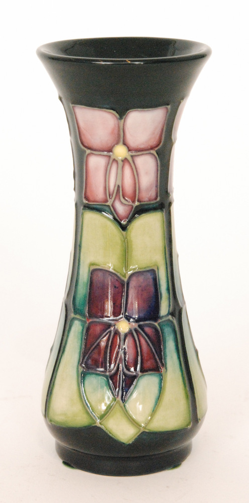 A small Moorcroft Pottery vase of slender form decorated in the Violet pattern designed by Sally