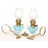 A pair of Art Nouveau style 20th Century oil lamps and shades with light blue reservoirs and brass