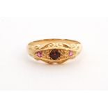 An early 20th Century 18ct hallmarked garnet and ruby three stone boat shaped ring with diamond