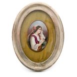 An early 20th Century small oval hand painted plaque depicting a young lady with long brown hair