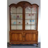 A walnut dome topped display cabinet in the Queen Anne style,