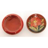 A small Moorcroft footed bowl decorated in the Flambe Freesia pattern with a central flower against