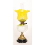 A Victorian oil lamp and yellow etched shade with moulded and embossed reservoir on black glazed