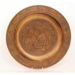 A 19th Century Black Forest carved walnut dish with raised border,