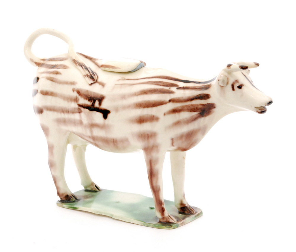 An early 19th Century Staffordshire creamware cow creamer and cover with streaked brown Whieldon