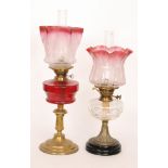 A 20th Century brass oil lamp and shade engraved with urns and swags with ruby reservoir,