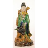 A Chinese porcelain standing figure dressed in green robes with a curled dragon wrapped from the