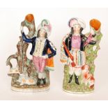 A pair of 19th Century Staffordshire flatback spill vases both with figures in Scottish dress,