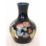 A Moorcroft vase of globe and shaft form decorated in the Clematis pattern with a band of flowers