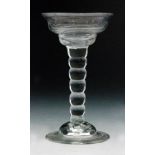 An 18th Century sweetmeat glass circa 1720, double ogee bowl above a seven section bobbin stem,