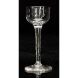 A late 18th Century cordial glass, the cup bowl above a slender plain stem and conical foot,