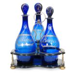 A late Georgian three bottle decanter stand circa 1820, the papier mache stand with brass feet,