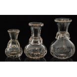 A 19th Century graduated set of three glass whisky measures of fluted globe and shaft form,