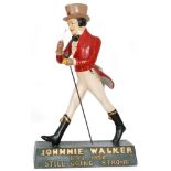 A large Johnnie Walker advertising counter top figure, he in walking stance and holding his cane,