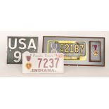 An American licence number plate for Purple Heart PH 2187 mounted on a board with medal and box and