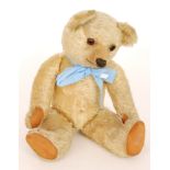 An early 1930s Chad Valley blond plush teddy bear with brown glass eyes,