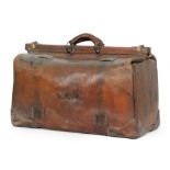 A large Edwardian brown leather Gladstone type bag with cantilever action and oval makers plaque to