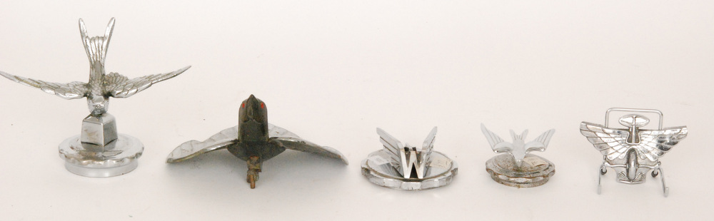 A 1940s insect deflector, two 1930s swift chrome mascots,