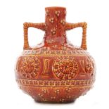 A late 19th to early 20th Century Burmantofts twin handled vase decorated in a tonal red and