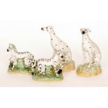 A pair of 19th Century Staffordshire models of Dalmatian hounds sat on naturalistic bases,